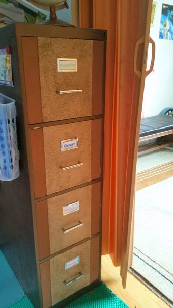 This is a file cabinet Emily painted and decorated. They use it for the kids to keep their school work and homework. Each child has a drawer he or she can easily reach with labeled folders inside. She says it really helps control the clutter and makes it easy to find papers. Emily stores extra supplies in the top drawer.
